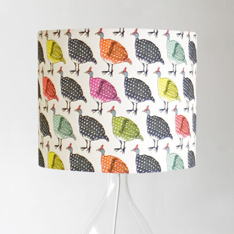Full image of handmade drum lampshade featuring colourful guinea fowl on light background textile design by Made by Ilze