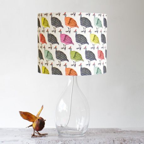 Colourful vintage guinea fowl on light background on drum stand lampshade on a retro glass lampstand
